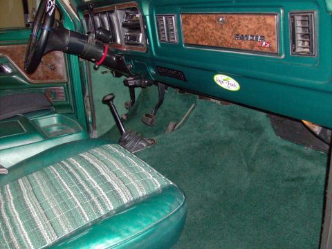 1978 Ford Bronco - The interior of this 1978 Ford Bronco features green carpeting and seats with a plaid pattern.