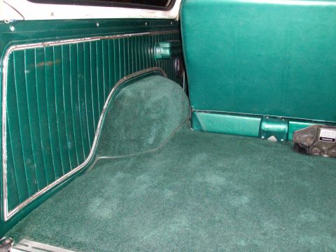 1978 Ford Bronco - Interior view of a vehicle's cargo area, green carpeting and ribbed side paneling.