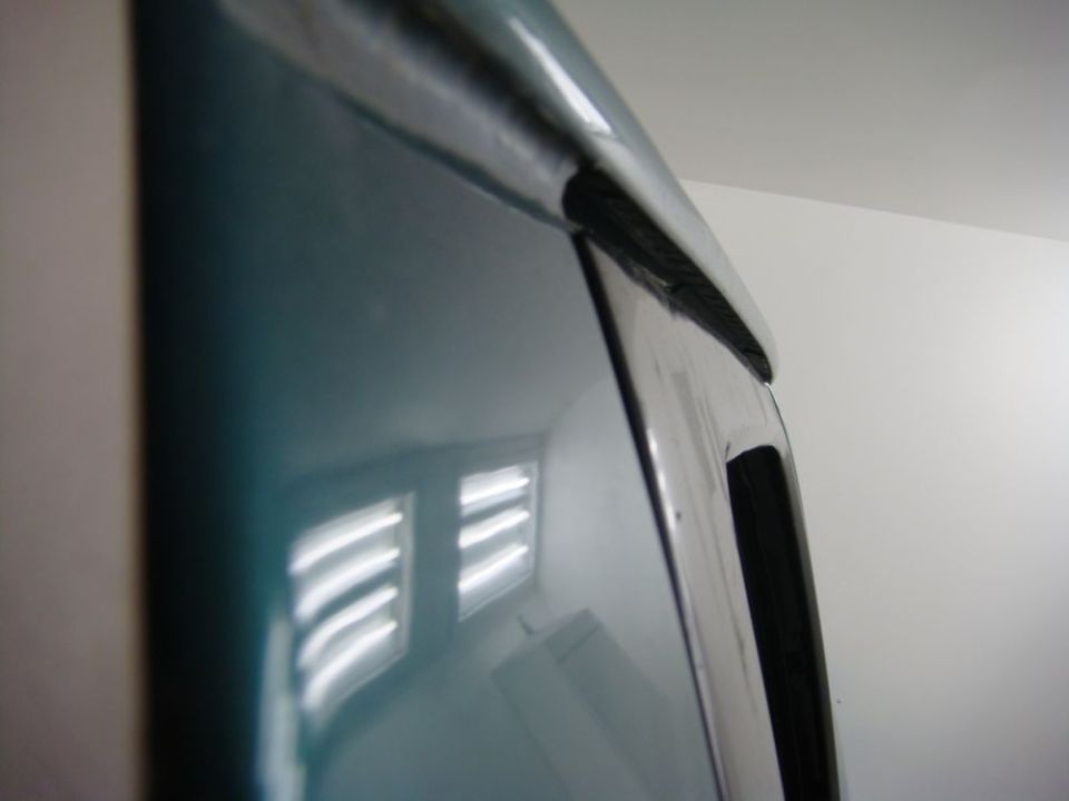 Teal car door trim with chrome accent and black rubber seal