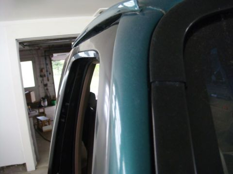 1996 Ford Bronco - Close-up view of the door frame and window trim on a teal SUV.