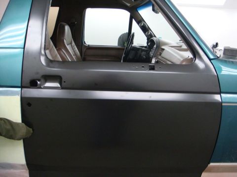 1996 Ford Bronco - The driver's side door panel of a Ford Bronco is shown, with the interior visible through the open door.