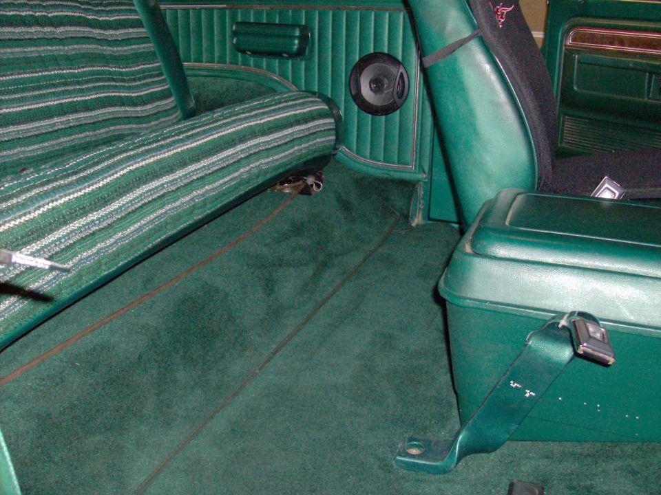Green interior of a 1978 Ford Bronco with striped seats and carpet