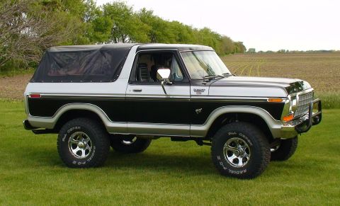 1979 Ford Bronco - This two-tone 1979 Ford Bronco features a black soft top and a chrome grille guard.