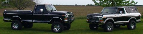 1979 Ford Bronco - Two Ford trucks, a pickup and a Bronco, are parked side-by-side on a grassy field.