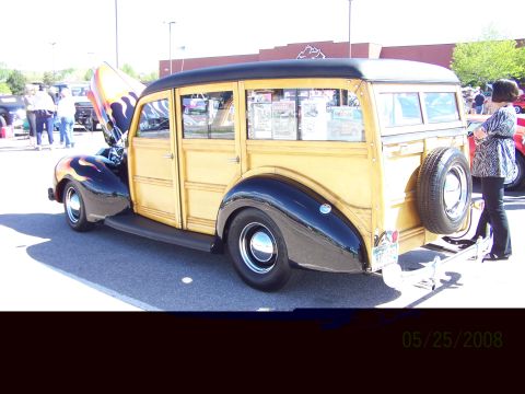 1972 Ford Ranchero - A classic woodie station wagon with custom flame paint is displayed at a car show.