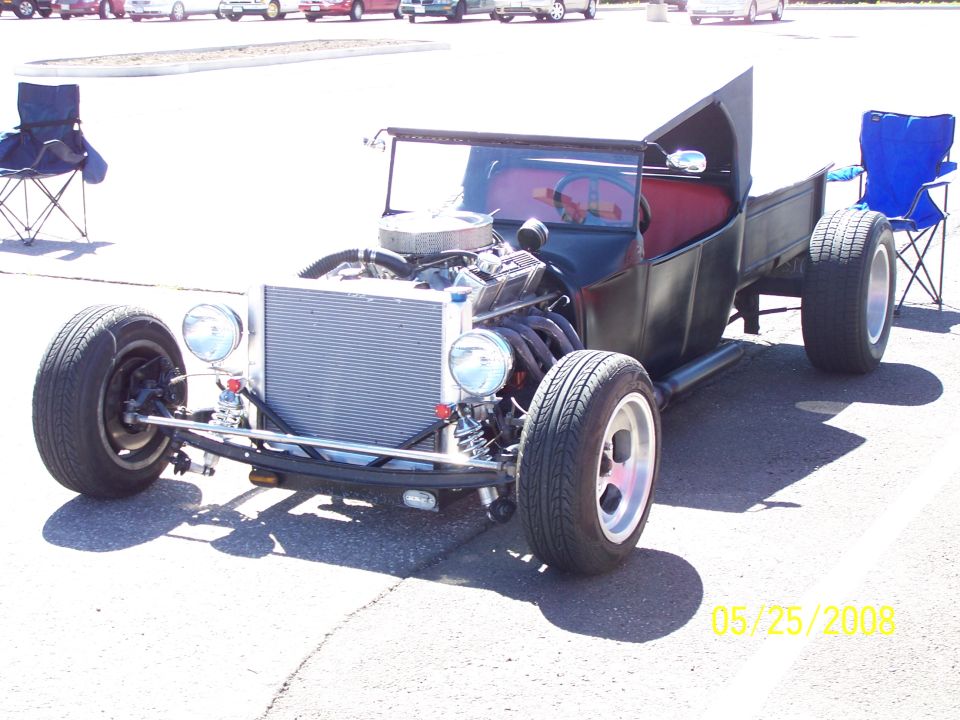 Black hot rod pickup truck with exposed engine and red interior