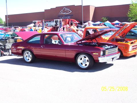1972 Ford Ranchero - A maroon coupe and an orange truck are displayed with hoods up at an outdoor car show.