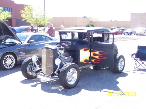 1972 Ford Ranchero - A custom hot rod with flame decals is displayed at an outdoor car show.