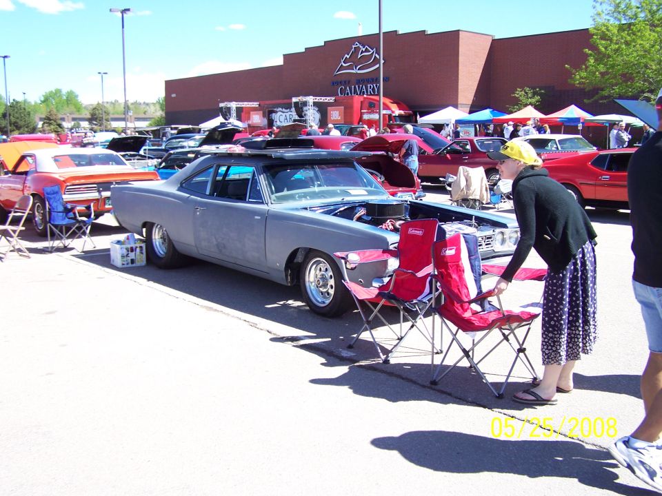 Gray 1969 Dodge Charger coupe with hood open, parked at an outdoor car show