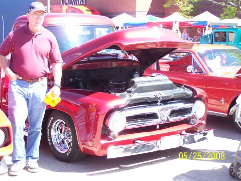 1972 Ford Ranchero - A man stands by a classic red pickup truck at an outdoor car show, with the engine exposed for viewing.