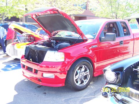 1972 Ford Ranchero - A red pickup truck is displayed with its hood open at an outdoor car show.