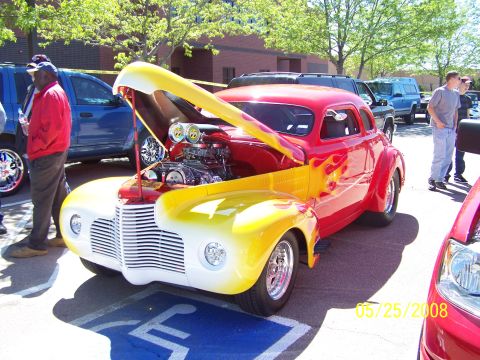 1972 Ford Ranchero - A custom hot rod with a powerful engine is displayed at a car show.