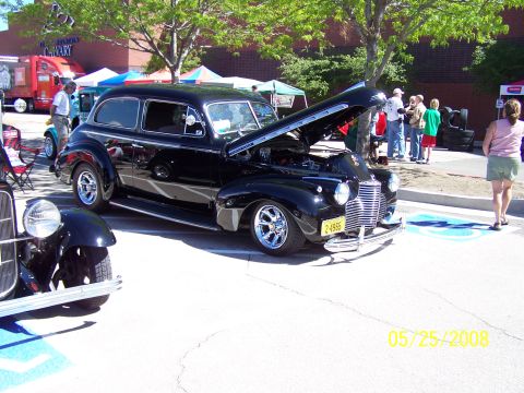 1972 Ford Ranchero - Black sedan from the 1940s displayed with its hood open at a car show event.