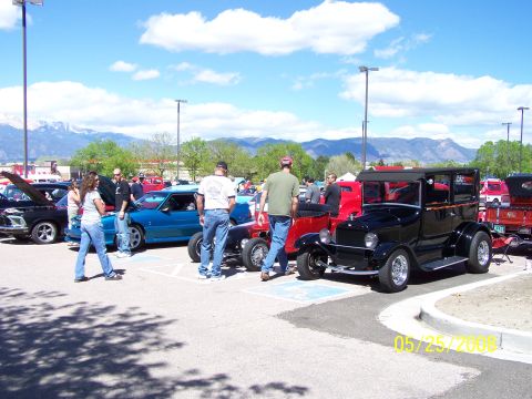 1972 Ford Ranchero - People mill around a variety of vehicles at an outdoor car show on a sunny day.