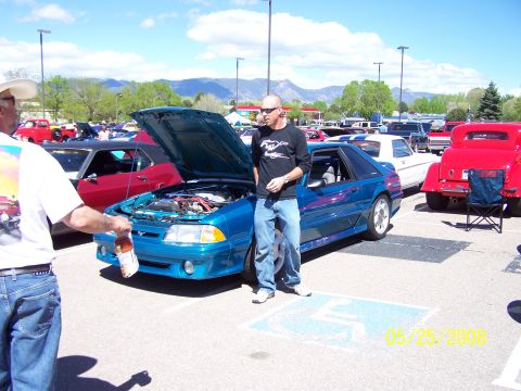 1972 Ford Ranchero - A blue Ford Mustang is displayed at a car show with its hood open, surrounded by other vehicles.