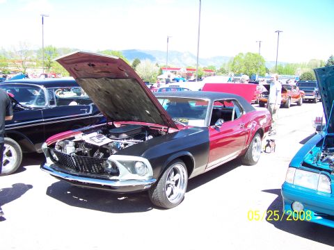 1972 Ford Ranchero - A two-tone red and black 1969 Ford Mustang is displayed with its hood open at a car show.