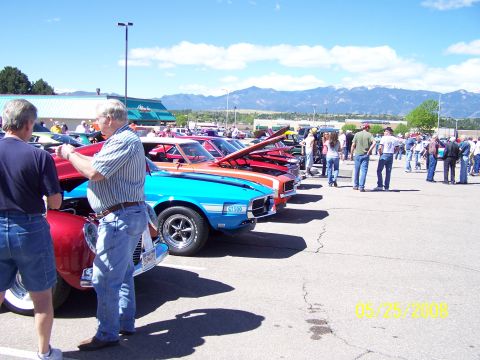 1972 Ford Ranchero - Several classic cars are on display at an outdoor car show with mountains in the background.