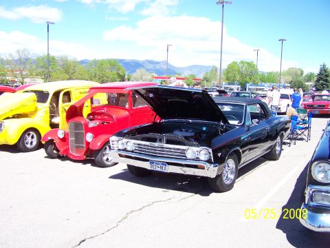 1972 Ford Ranchero - A black convertible, likely a 1966 model, is displayed with its hood open at a car show. Other vehicles are visible in the background.