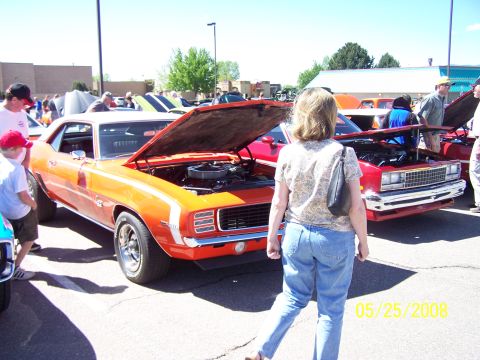 1972 Ford Ranchero - A classic orange muscle car with its hood open is displayed at an outdoor car show.