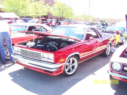 1972 Ford Ranchero - A red El Camino is displayed at a car show with its hood open, revealing the engine.