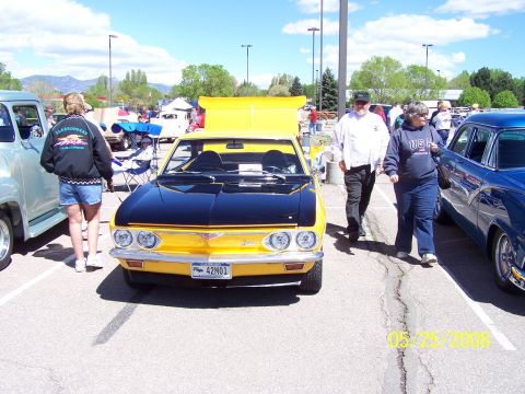 1972 Ford Ranchero - Yellow 1972 Chevrolet Corvair with black hood at a car show. Other vehicles and people are visible.