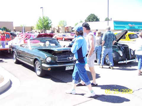 1972 Ford Ranchero - A green convertible is displayed at a car show with people milling around.