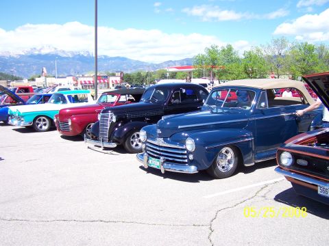 1972 Ford Ranchero - A collection of vintage automobiles are displayed at an outdoor car show under a bright blue sky.