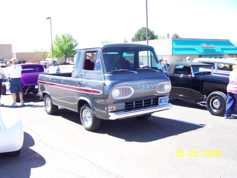 1972 Ford Ranchero - A vintage Ford Econoline pickup truck is displayed at an outdoor car show with other vehicles.