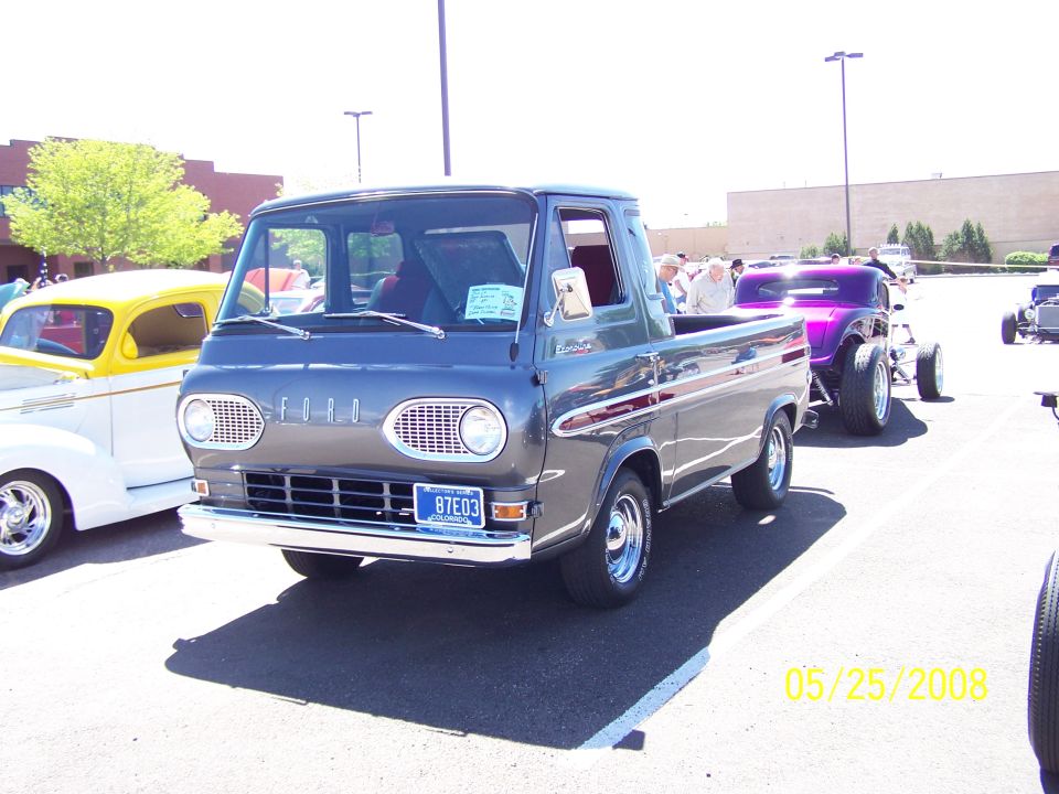 Gray Ford Econoline pickup truck with red stripe, front view. License plate 87E03