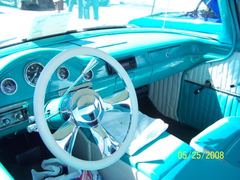 1972 Ford Ranchero - The interior of a turquoise classic car features a white steering wheel and custom upholstery.