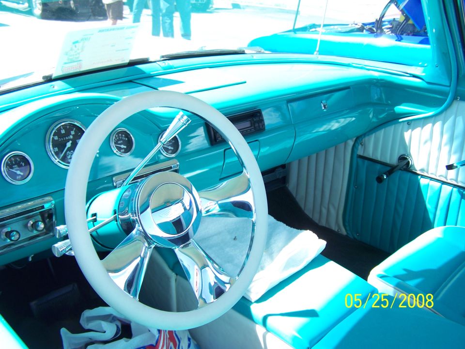 Turquoise car interior with a white steering wheel, dashboard gauges, and padded seats. Date stamp '05/25/2008' is visible