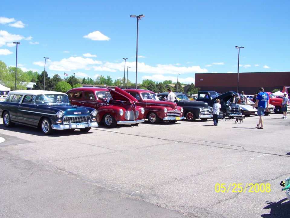 Row of vintage cars including a Chevy Nomad wagon at a car show
