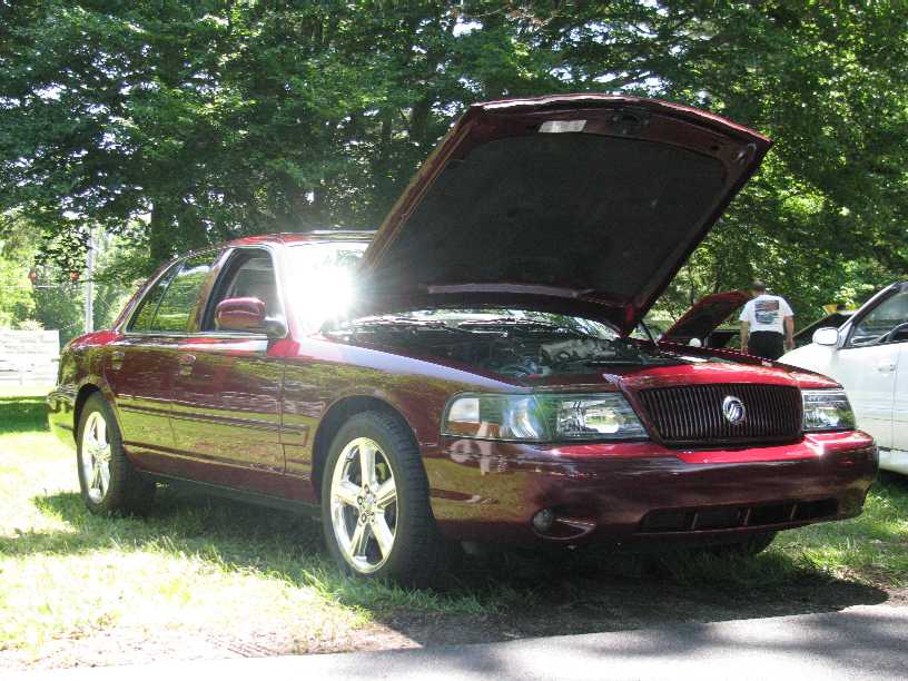 Dark red Mercury Marauder sedan with hood open at an outdoor show