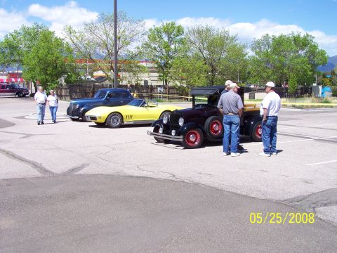 1972 Ford Ranchero - Three men stand near a black antique pickup truck at a car show on a sunny day.