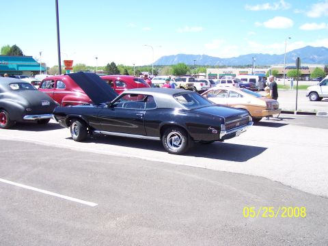 1972 Ford Ranchero - A black 1970 Mercury Cougar is displayed at a car show with other vehicles in the background.