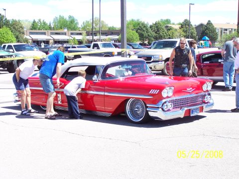1972 Ford Ranchero - A bright red 1958 convertible with a white top and chrome wire wheels is admired by onlookers at a car show.