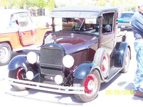 1972 Ford Ranchero - A 1930 Ford Model A pickup truck is parked next to another vehicle.