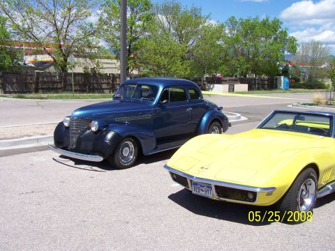 1972 Ford Ranchero - Two classic cars, a blue coupe and a yellow convertible, are parked together at an outdoor car show.