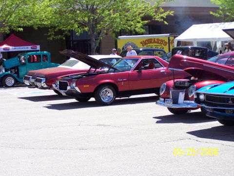 1972 Ford Ranchero - Several classic cars are displayed at an outdoor event, including a red 1972 Ford Ranchero with its hood open.