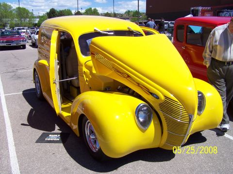 1972 Ford Ranchero - A yellow panel van is parked at a car show next to a red vehicle.