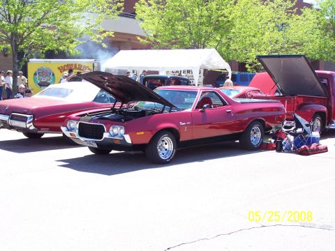 1972 Ford Ranchero - A red coupe utility and a red pickup truck are parked at an outdoor event with their hoods and tailgates open.