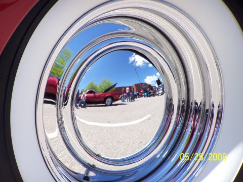 1972 Ford Ranchero - A red 1972 Ford Ranchero is reflected in its chrome hubcap at a car show.