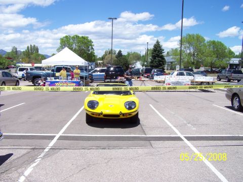 1972 Ford Ranchero - A yellow sports car is the focus at an outdoor car show with multiple vehicles present.