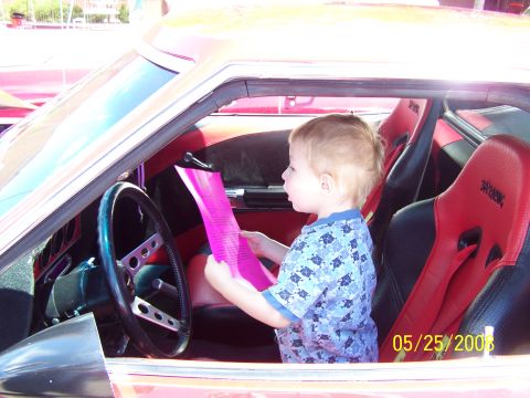 1972 Ford Ranchero - Child sits in the driver's seat of a 1972 Ford Ranchero, looking at a piece of paper.
