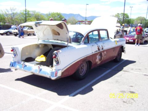 1972 Ford Ranchero - A weathered 1956 Chevrolet Bel Air is displayed with its trunk and hood open at an outdoor car show.
