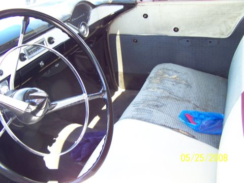 1972 Ford Ranchero - Interior of a 1955 Chevrolet, showing the steering wheel, dashboard, and worn seat. Date stamp visible.