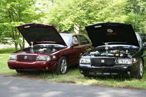 2003 Mercury Marauder - Two Mercury Marauders, a red and a black model, are displayed with their hoods open at a car show.