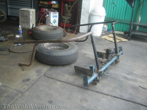 1987 Suzuki Samurai - A trailer hitch assembly is shown in a workshop with tires nearby.