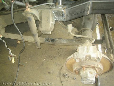 1987 Suzuki Samurai - Close-up view of the undercarriage of a vehicle, focusing on suspension and axle components.