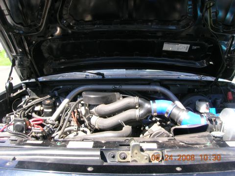 1996 Ford Bronco - The engine bay shows modifications including a turbocharger and custom intake piping.